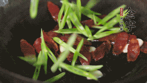 先后下香腸片、四季豆絲均勻翻炒，加適量清水燜煮一下。