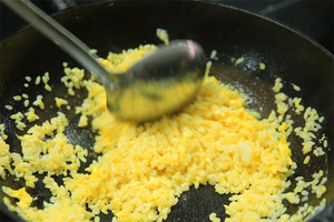 大火加熱炒鍋，再入油，燒到四至五成熱時倒入雞蛋液，在未凝結(jié)之前，加米飯煸炒，不停翻炒并用鍋鏟將成塊的米飯碾開、撥散。